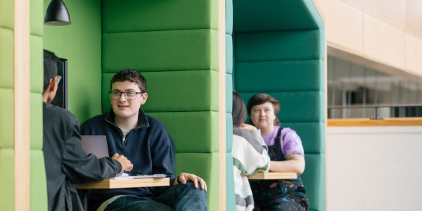 Students sitting at tables in Learning and Teaching Building