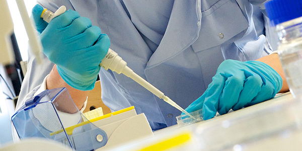 Biomedical Engineering student using a pipette in a lab