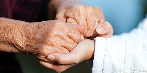 Young and older adult holding hands