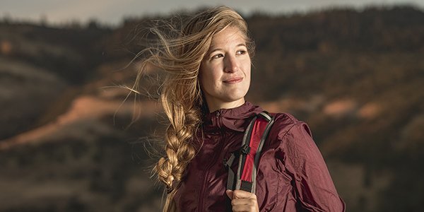 A young female hiker up early, looking optimistic.