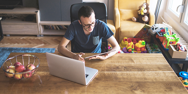 A young man working on the digital tablet at home in the living room.