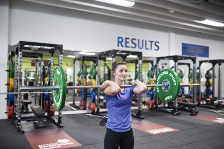 Janice Buchanan (Lead Physical Performance Coach / Deputy Camp Director) setting up a front squat with a barbell. 