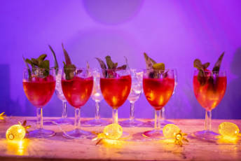 Five cocktail glasses with a very pink colour drink.