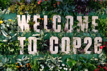 The words “Welcome to COP26” among plants.