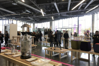 Display of products resulting from eco and circular design, with people looking at them.