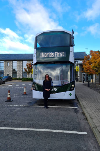 The author of the photo stands in front of a bus that says “Worlds First”.