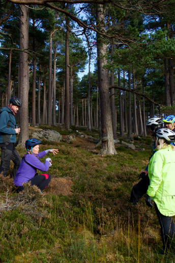 A group of people wearing bicycle helmets are listening to a talk by author of photo.