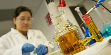 Chemical Engineering Laborotory Researcher Girl with Orange Liquid Experiment 360x180