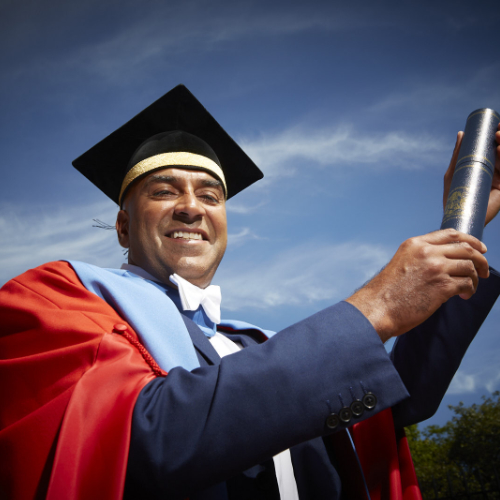 Dr Amar Latif headshot with graduation gown and scroll