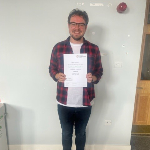 Dr Jon Devlin standing with his certificate
