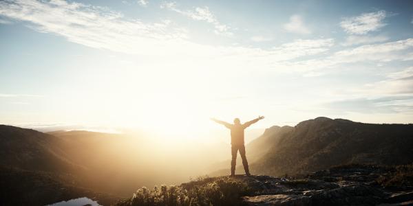 man arms up mountains sunshine