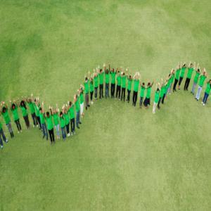 Group in green shirts forming snake line