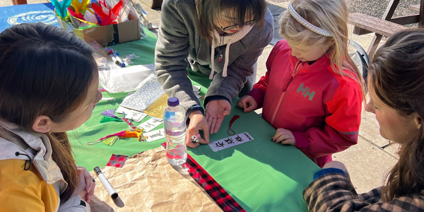 Teacher showing visitor their name written in Chinese on a bookmark