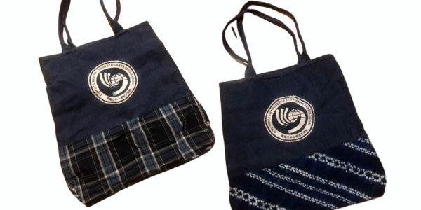 Two tote bags with the Confucius Institute for Scotland's Schools logo, one tartan, one Chinese tie-dye