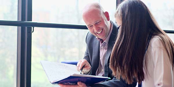 Man and woman looking at book and smiling