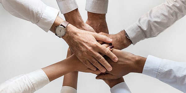 Colleagues placing hands in a circle