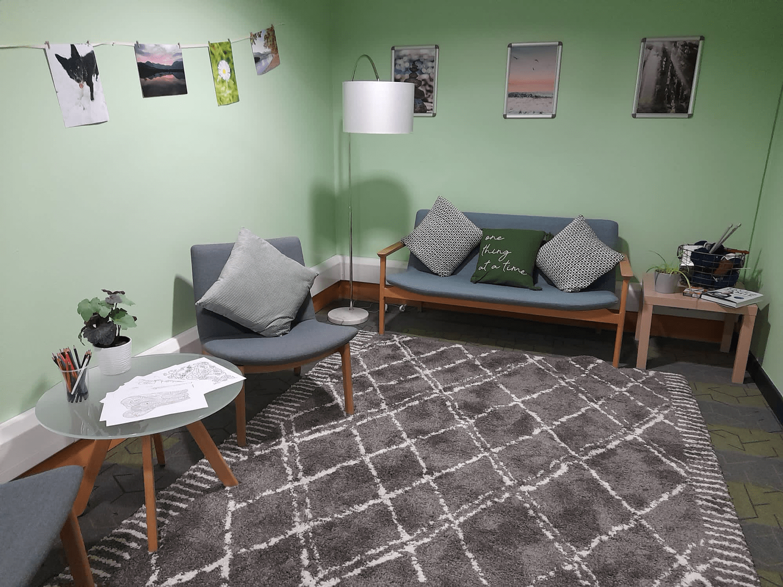 A corner of the Library with sofas, lamps and a rug.