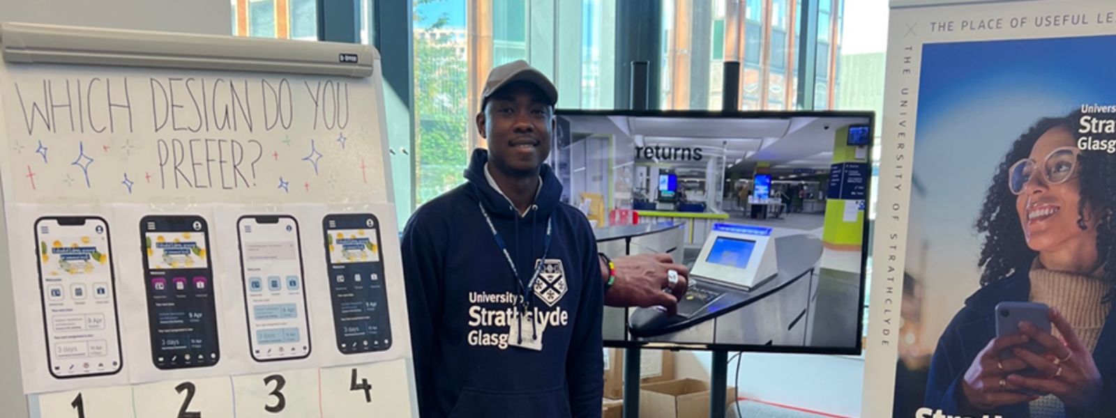 A student at Freshers Fair with a board showing four design options