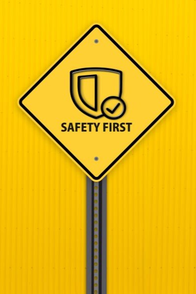 A black and yellow sign that says safety first against a yellow background