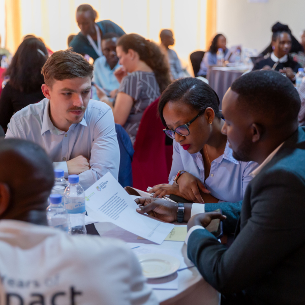 A group of people sit around a conference table looking at some documents