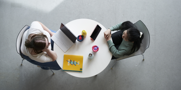 Two people in conversation at a table