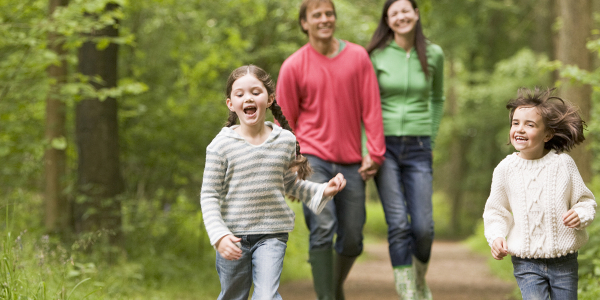 Two children walking in front of two adults