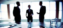 Three silhouettes in a boardroom 